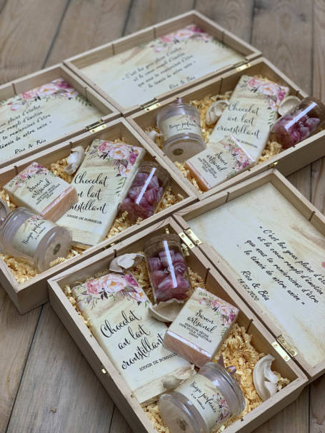 trois coffrets à cadeaux à offrir contenant une tablette de chocolat, une bougie parfumée, un savon artisanal et une verrine à dragées